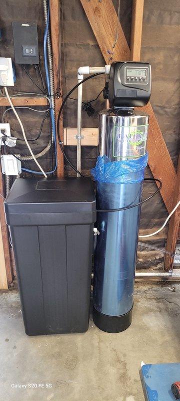 Completed installation of a comprehensive water treatment system in an unfinished utility area. Installed a primary water filtration tank with digital control head alongside a complementary brine tank/water softener, connecting both units to the existing plumbing and electrical systems. System was properly secured and tested to ensure optimal water quality and treatment functionality.