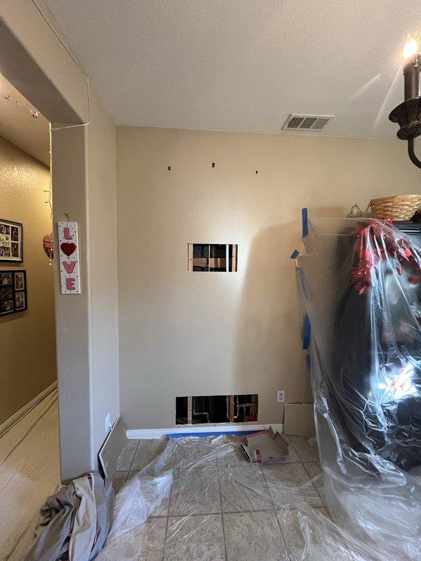 Performed leak detection inspection at customer's residence during renovation work. Located water intrusion source behind drywall near the Bradford White Eco Defender water heater installation. Created access openings in wall to inspect copper supply lines and identified pinhole leak in pipe fitting. Repaired affected section and verified system integrity before closing inspection.