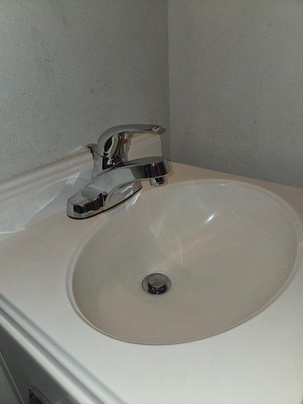 Inspected bathroom sink and faucet fixture. Documented condition of chrome single-handle faucet and white porcelain basin. Noted minor wall cracking near backsplash area. No active issues observed with plumbing components.