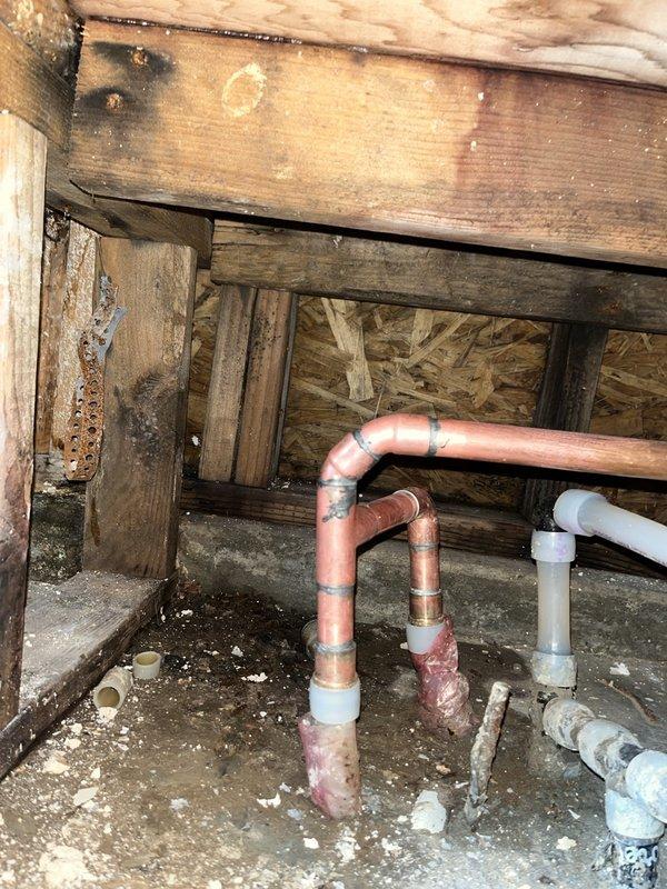 Performed inspection of crawlspace area revealing plumbing configuration with copper and PVC pipes. Identified and documented areas of water intrusion affecting wooden structural components including joists, beams, and OSB sheathing. Completed remediation work on exposed framing, installed new copper piping connections with properly soldered joints, and verified integrity of flexible metal conduit transitions. Moisture barriers were assessed and reinforced where necessary.
