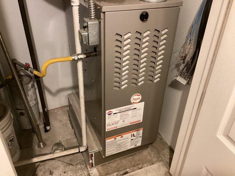 Responded to service call for air conditioning system blowing warm air in residential property with 5-year-old equipment. Inspected Payne furnace unit located in laundry room and outdoor condensing unit to diagnose cooling failure. Performed system evaluation including refrigerant levels, electrical connections, thermostat operation, and airflow assessment to identify root cause of heating mode operation during cooling demand.
