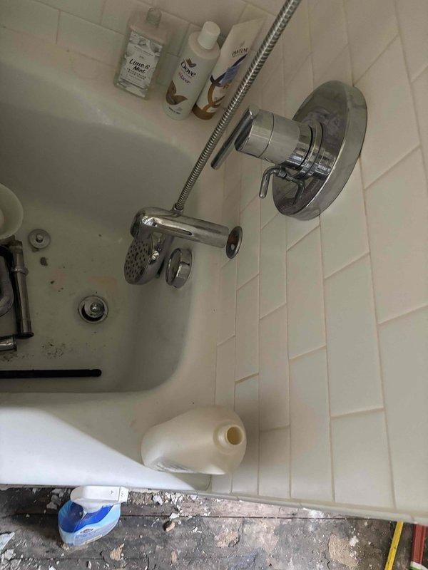 Completed full bathroom group drainage replacement involving access through wood panel ceiling from below. Removed existing toilet drain, complete tub waste and overflow assembly, drum trap, and deteriorated sink drainage piping. Installed new ABS plastic individual wye fittings for each fixture to ensure proper drainage and code compliance. Installed new tub waste and overflow with p-trap and chrome drain assembly for bathtub. Set new toilet flange and adapted connections to existing serviceable piping sections for sink drain. All horizontal drain runs completed as planned without requiring additional vertical piping modifications.