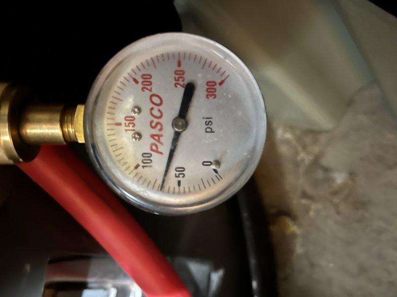 Responded to service call for two 50-gallon tank water heaters in basement, with one unit failing to ignite despite pilot light remaining lit after relighting. Performed diagnostic testing and pressure measurements on malfunctioning unit, recording system pressure at approximately 250 psi using calibration gauge. Inspected gas control valve assembly and sight glass window for proper operation and flame verification. Completed maintenance flush service on both 10-year-old water heater tanks to remove sediment buildup and restore optimal heating efficiency.