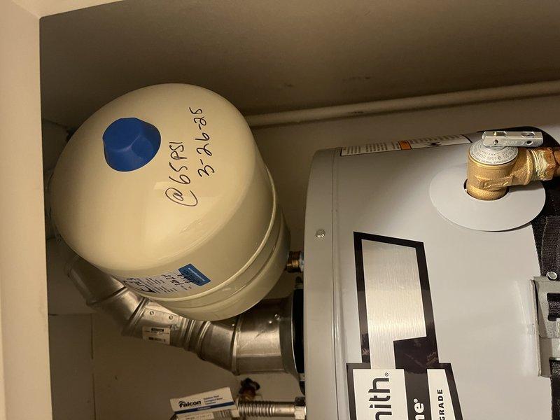 Responded to a no hot water complaint on an approximately one-year-old tank-type water heater. Upon arrival, performed diagnostic evaluation of the unit and associated components, including inspection of the water heater controls, heating elements, and gas/electric supply connections. Documented existing conditions with photographic evidence showing the water heater installation in utility closet with visible service markings and connected plumbing fixtures. Unit was assessed for proper operation and potential causes of hot water failure, including thermostat function, pilot light or ignition system status, and supply line integrity.
