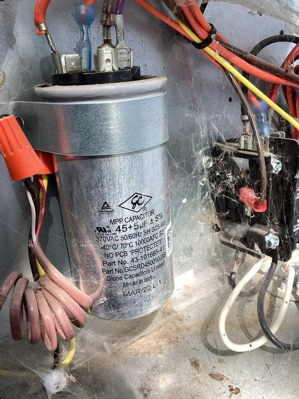 Completed Green Shield cooling maintenance on residential air conditioning unit located at rear of property. Performed comprehensive inspection of outdoor unit electrical components including capacitor (370VAC, manufactured March 2022) and contactor assembly, verified all wire connections and terminals secure, cleaned accumulated dust and debris from electrical compartment and components. All systems tested and operating within normal parameters upon completion of preventive maintenance service.