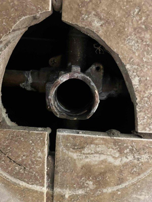 Responded to water leak emergency in main level bathroom where water was dripping from ceiling. Customer had removed ceiling sheetrock and attempted to access shower valve, breaking the cartridge in the process and disabling water flow. Accessed plumbing through floor opening, assessed damaged shower valve cartridge and corrosion on fixtures. Documented conditions via photos showing access point through tile floor and compromised plumbing components requiring cartridge replacement to restore shower function.