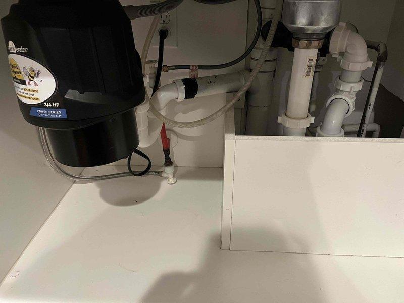 Responded to kitchen sink clogging issue. Upon arrival, inspected under-sink plumbing assembly including 3/4 HP Power Series Contractor 333 garbage disposal unit, P-trap configuration, and associated white PVC drainage lines. Assessed entire drain system for blockages and proper flow. Cleared obstruction from kitchen sink drain line, restoring full drainage capability. Verified garbage disposal operation and confirmed all plumbing connections were secure with no leaks present. Tested water flow through disposal and drain assembly to ensure complete resolution of clogging issue.
