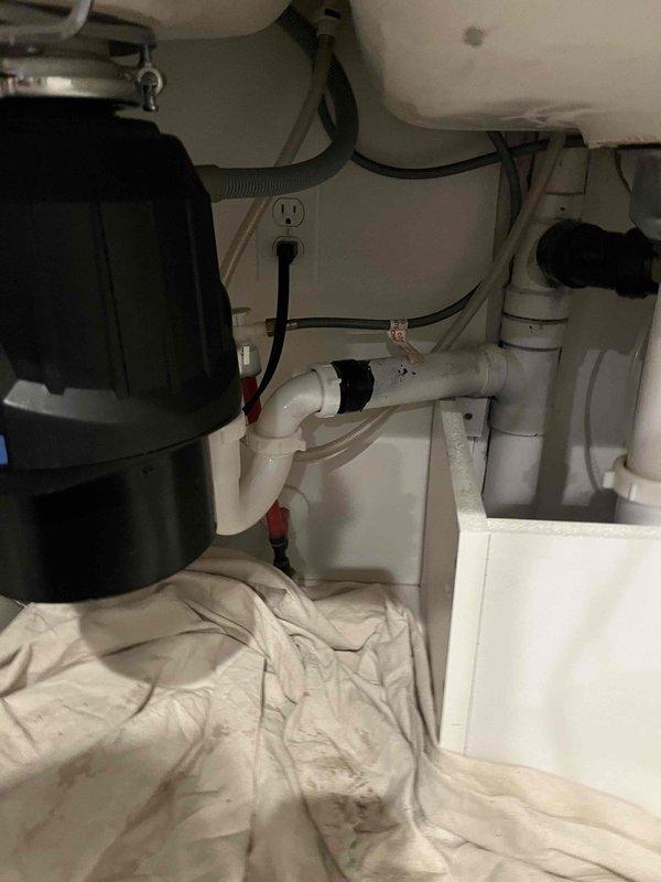 Responded to kitchen sink clogging issue. Upon arrival, inspected under-sink plumbing assembly including 3/4 HP Power Series Contractor 333 garbage disposal unit, P-trap configuration, and associated white PVC drainage lines. Assessed entire drain system for blockages and proper flow. Cleared obstruction from kitchen sink drain line, restoring full drainage capability. Verified garbage disposal operation and confirmed all plumbing connections were secure with no leaks present. Tested water flow through disposal and drain assembly to ensure complete resolution of clogging issue.