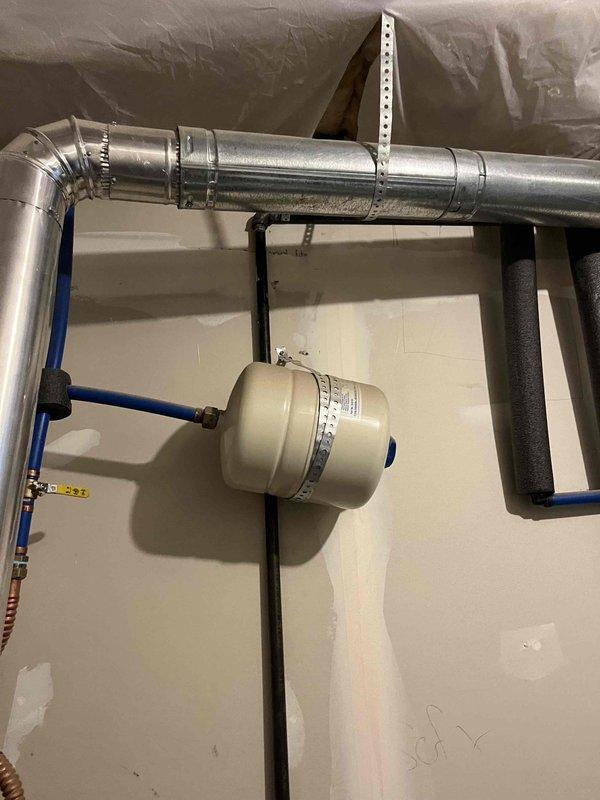 Responded to reported leak from bottom of 8+ year old tanked water heater in basement. Upon inspection, determined unit had reached end of serviceable life with tank failure causing water discharge. Removed and disposed of failed water heater. Installed new Rheem Classic tanked water heater with proper venting through metal flue pipe, connected hot and cold water supply lines using flexible corrugated connectors with brass fittings, and installed expansion tank with blue rigid piping and appropriate mounting. Tested all connections for leaks, verified proper operation, and confirmed system functionality.