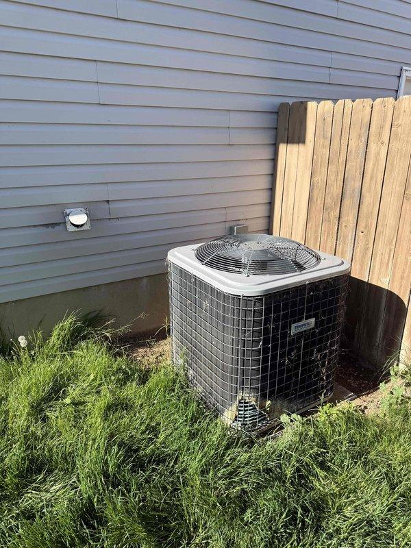 Performed estimate on 4-5 year old residential air conditioning condenser unit reported as non-operational. Previous technician from another company had deemed unit non-repairable. Upon inspection, condenser exhibited extensive corrosion and damage to exterior coil and components due to prolonged pet urine exposure. Visual assessment confirmed significant deterioration of condenser coil fins, protective mesh guard showing weathering, and base components displaying heavy contamination and corrosion. Unit positioned on ground-level pad against building exterior with adequate clearance but showing signs of environmental damage and debris accumulation around base. Recommended condenser replacement as most viable solution given extent of corrosion damage to critical components and age of equipment. Presented replacement options to homeowner with emphasis on condenser-only replacement per customer preference, as remaining system components were recently installed. Customer expressed interest