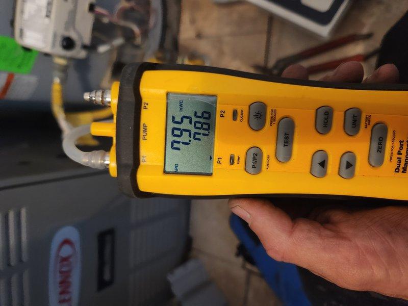 Responded to service call for tank water heater with pilot light that would not remain lit. Upon arrival, performed diagnostic evaluation of gas control valve, thermocouple, and pilot assembly. Utilized digital diagnostic equipment to test system pressure and verify proper gas supply to unit. Inspected pressure gauge readings on water heater tank, confirming adequate water pressure within normal operating range of 0-250 PSI. Examined pilot assembly, thermocouple positioning, and gas valve operation to determine root cause of pilot light failure. Assessed all visible plumbing connections, copper supply lines, and electrical wiring for proper installation and safety compliance. Documented equipment condition through diagnostic photography showing pressure monitoring components and brass fittings in utility area installation.