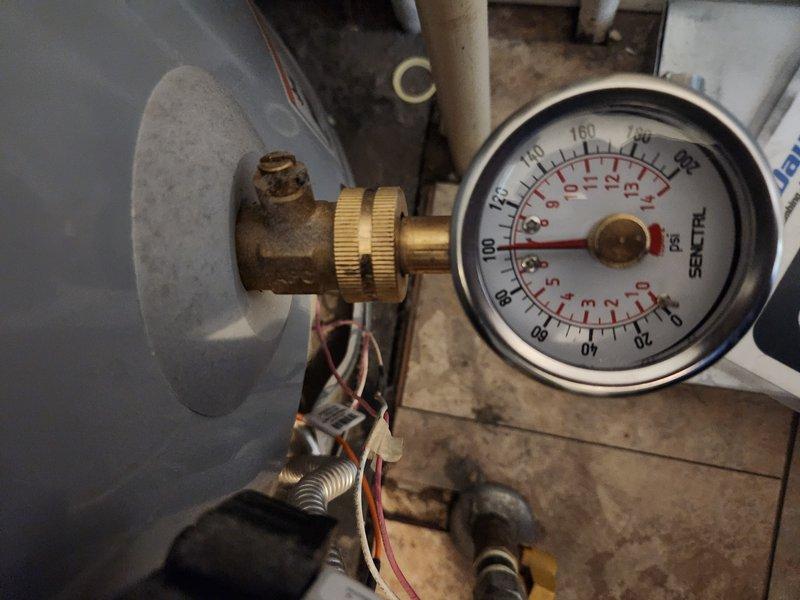 Responded to service call for tank water heater with pilot light that would not remain lit. Upon arrival, performed diagnostic evaluation of gas control valve, thermocouple, and pilot assembly. Utilized digital diagnostic equipment to test system pressure and verify proper gas supply to unit. Inspected pressure gauge readings on water heater tank, confirming adequate water pressure within normal operating range of 0-250 PSI. Examined pilot assembly, thermocouple positioning, and gas valve operation to determine root cause of pilot light failure. Assessed all visible plumbing connections, copper supply lines, and electrical wiring for proper installation and safety compliance. Documented equipment condition through diagnostic photography showing pressure monitoring components and brass fittings in utility area installation.