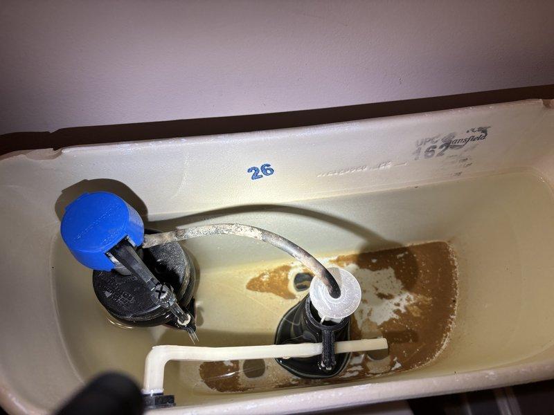 Responded to reported leaks at toilet and bathroom sink. Inspected toilet tank and identified leak originating from bottom of tank, noting significant mineral deposits and corrosion on internal components and tank surfaces. Examined bathroom sink with oil-rubbed bronze fixtures and confirmed leak condition. Documented both fixtures with photographs for assessment and repair recommendations.