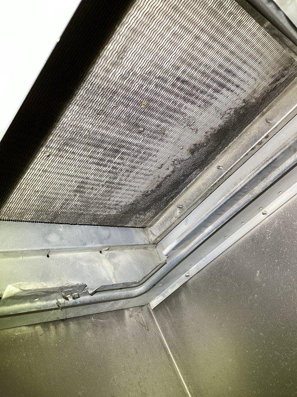 Responded to no-cooling complaint on approximately 10-year-old Tempstar residential forced-air system located in basement utility area. Performed diagnostic evaluation of air handler and associated components. Inspected air filter condition and found moderate dust accumulation on mesh filter media. Examined furnace cabinet, condensate drainage system with PVC piping, and refrigerant line connections. Documented equipment condition through photographic inspection of air handler interior and filter housing assembly.