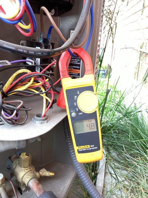 Completed annual air conditioner tune-up on residential split system with outdoor condensing unit and indoor furnace. Performed electrical diagnostics on outdoor unit using clamp meter, measuring amp draw at 48 amps on refrigerant lines and verifying proper electrical operation. Inspected outdoor unit components including copper refrigerant lines with insulation, control wiring, brass service valves, and conduit connections. Evaluated indoor furnace system located in basement, checking gas line connections, PVC vent piping, ductwork, and overall system integration. All equipment operating within normal parameters with no issues identified during maintenance inspection.