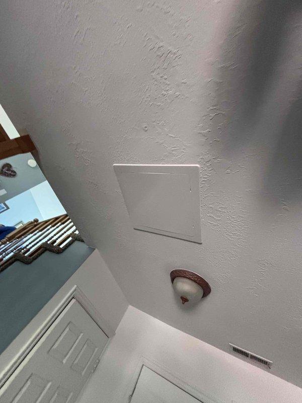 Responded to reported spongy flooring adjacent to shower area in bathroom. Conducted leak investigation to determine source of moisture intrusion causing structural damage to subfloor. Accessed attic space through ceiling panel to inspect plumbing lines and drain connections above affected bathroom. Documented ceiling conditions and access points for further remediation work.