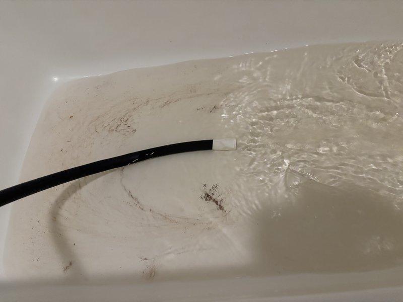 Responded to complaint of brown water throughout home from dual water heater system in basement. Inspected both tanked units (one 2-3 years old, one 7 years old) and identified severe sediment buildup in older unit that had not been flushed in nearly 10 years, causing discolored water distribution. Evaluated anode rod condition, tested water quality, and assessed water softener functionality which was also over 10 years old and potentially contributing to the issue. Provided maintenance recommendations including tank flushing, anode rod replacement, and water softener testing to restore water quality and extend equipment lifespan. Presented replacement options for aging unit including 40-gallon and 50-gallon tanked water heaters with warranty coverage.