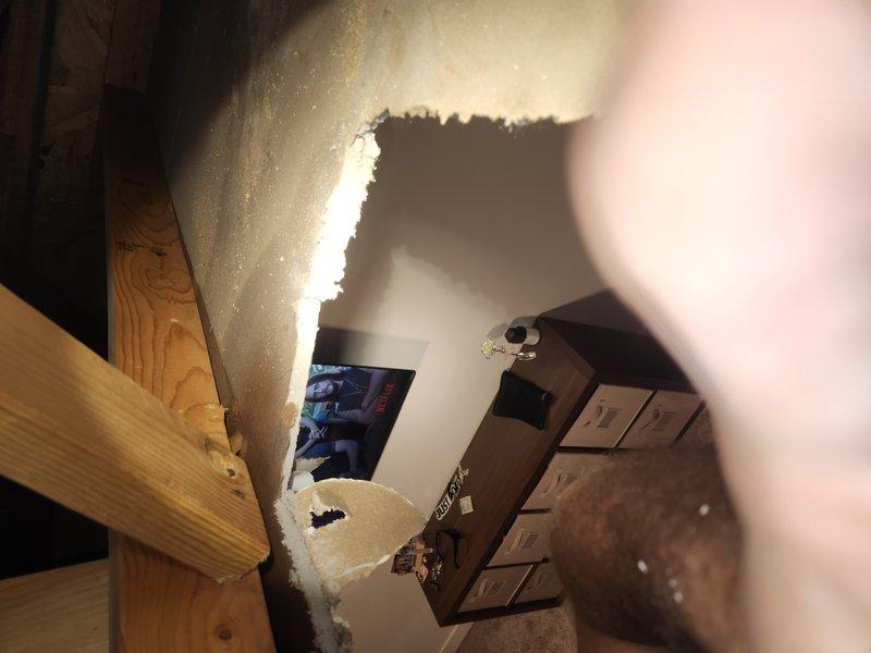 Responded to active water leak in basement bedroom ceiling with visible bubbling and damage to drywall. Removed damaged section of ceiling drywall to access leak source and identify plumbing line causing water intrusion. Inspected exposed framing, piping, and surrounding structure to assess extent of damage and determine repair requirements.