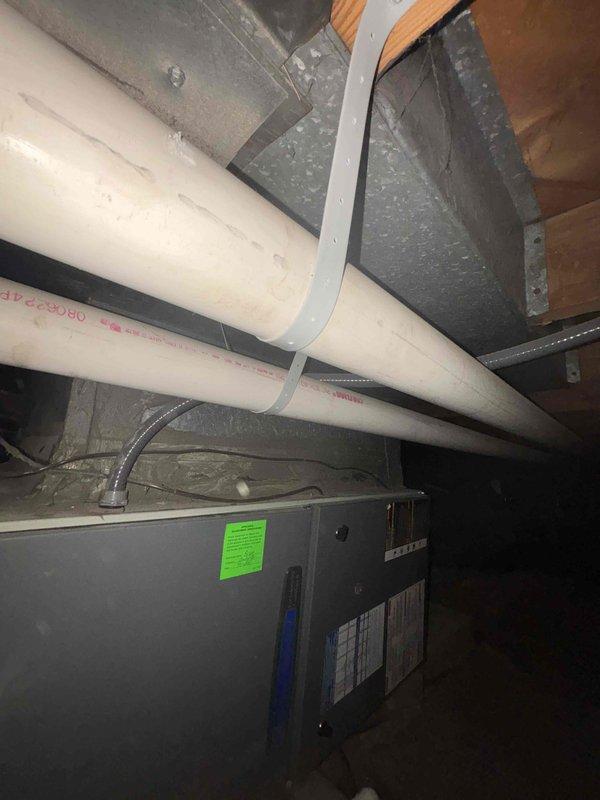 Conducted system evaluation of residential HVAC air handler unit located in crawl space. Inspected air handler, refrigerant lines, PVC condensate drainage system, and ductwork connections. Documented equipment condition with photographs showing proper installation of drainage piping, copper refrigerant lines, and flexible conduit connections. Verified system operational status and confirmed all components functioning as designed with no immediate service needs identified.