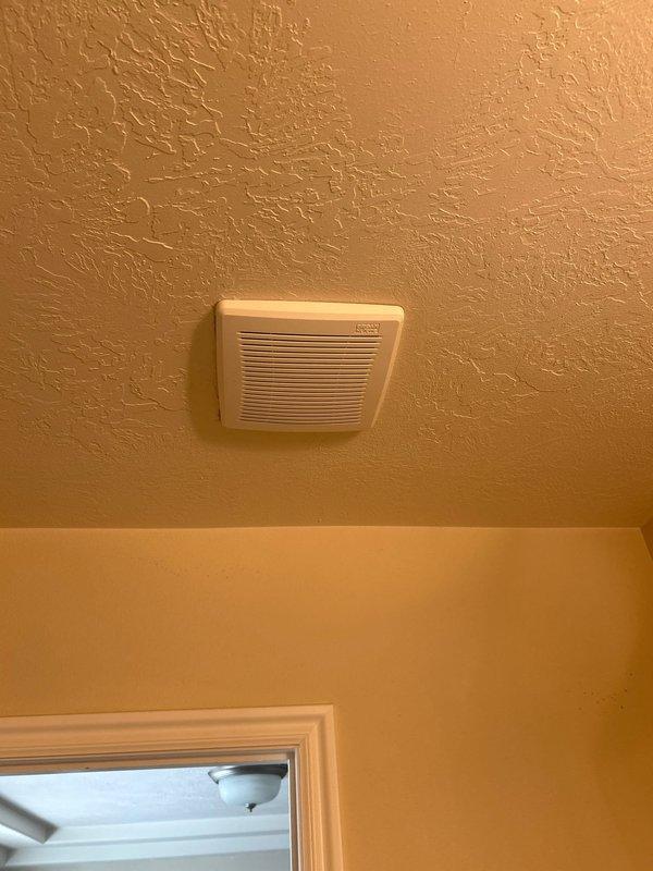 Serviced ceiling-mounted exhaust fan that had experienced reduced airflow and operational issues due to severe lint and debris accumulation. Removed ventilation cover, cleaned extensive buildup from fan blades, motor housing, and louver assembly, then verified proper operation and airflow upon reassembly.