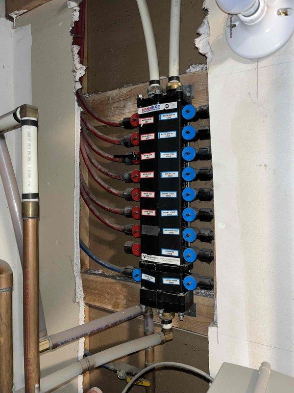 Responded to report of no hot water in middle floor bathroom fixtures while rest of home had normal hot water supply. Investigated PEX manifold distribution system and identified closed isolation valve preventing hot water flow to affected bathroom. Opened valve at manifold to restore hot water to sink and shower. Completed annual plumbing maintenance inspection including water heater evaluation and system pressure check.