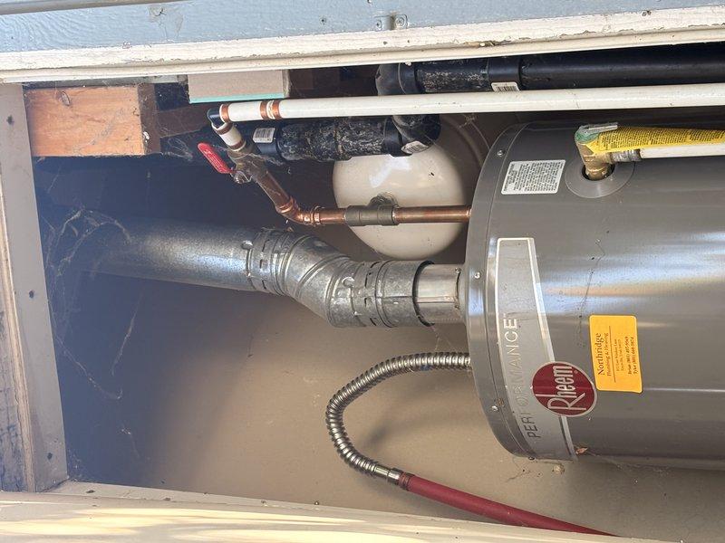 Performed comprehensive water heater flush and safety inspection on Rheem standard tank unit experiencing knocking sounds. Completed full system flush to remove sediment buildup, inspected all plumbing connections including copper supply lines and gas line, verified proper operation of temperature and pressure relief valve, and tested pressure gauge readings. Confirmed expansion tank installation and drain pan placement, examined all visible piping and connections for leaks or deterioration, and verified proper venting configuration.