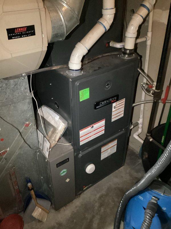 Responded to an HVAC system experiencing electrical component failure on a 15-year-old air conditioning unit with a Distinctions furnace. Upon inspection, diagnosed a failed dual capacitor, melted hard start kit, and melted wiring to the contactor, indicating significant electrical stress and potential safety hazards. Documented the condition of the system through photography, capturing the furnace installation with visible PVC condensate lines, electrical panel, and internal wiring configuration. Provided technical assessment and replacement options for the aging system, discussing both repair and full system replacement solutions given the age of the equipment and extent of electrical damage.