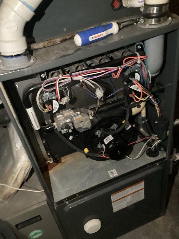 Responded to an HVAC system experiencing electrical component failure on a 15-year-old air conditioning unit with a Distinctions furnace. Upon inspection, diagnosed a failed dual capacitor, melted hard start kit, and melted wiring to the contactor, indicating significant electrical stress and potential safety hazards. Documented the condition of the system through photography, capturing the furnace installation with visible PVC condensate lines, electrical panel, and internal wiring configuration. Provided technical assessment and replacement options for the aging system, discussing both repair and full system replacement solutions given the age of the equipment and extent of electrical damage.
