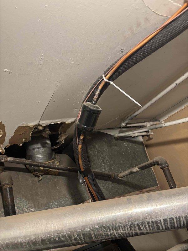 Completed scheduled cooling system maintenance on residential HVAC system. Performed comprehensive inspection of Goodman furnace and associated equipment in basement mechanical room. Checked refrigerant lines, ductwork connections, and system components for proper operation. Inspected flexible and rigid ductwork for secure installation and adequate insulation. Verified all mechanical systems operational and documented existing conditions including ceiling-mounted refrigerant lines, PVC drainage piping, and insulated supply lines showing normal condensation patterns.