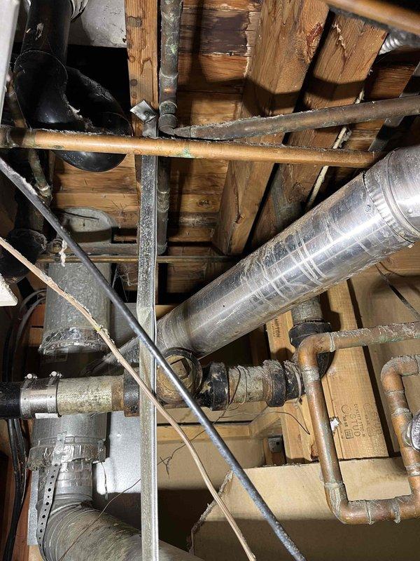 Responded to reported leak under kitchen sink initially suspected to be from copper solder fitting. Upon inspection, diagnosed actual source as deteriorated galvanized kitchen drain line showing active water seepage. Assessed plumbing configuration in utility space beneath sink area, including supply lines, shut-off valves, and drain assembly. Documented existing conditions of aged galvanized drain piping and surrounding plumbing infrastructure for repair recommendations.