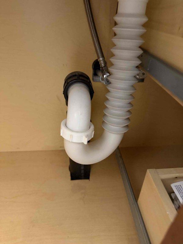 Responded to a clogged drain issue in a downstairs bathroom where the sink drainage was causing the adjacent laundry drain to overflow and flood within 30 seconds of running water. Cleared the blockage in the drain line, replaced the P-trap assembly with new white PVC components and proper fittings, and tested the system to verify proper drainage flow without backup to the laundry area.
