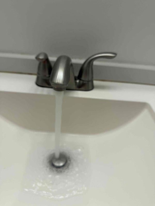 Responded to a clogged drain issue in a downstairs bathroom where the sink drainage was causing the adjacent laundry drain to overflow and flood within 30 seconds of running water. Cleared the blockage in the drain line, replaced the P-trap assembly with new white PVC components and proper fittings, and tested the system to verify proper drainage flow without backup to the laundry area.