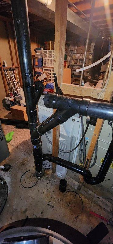 Completed full repipe of backgraded drain system, connecting kitchen drain line to new piping and capping off existing septic connection. Removed and reset two toilets with new flange connections at each location. Adjusted laundry drain P-trap to lower position to achieve proper drainage rise and code-compliant configuration.