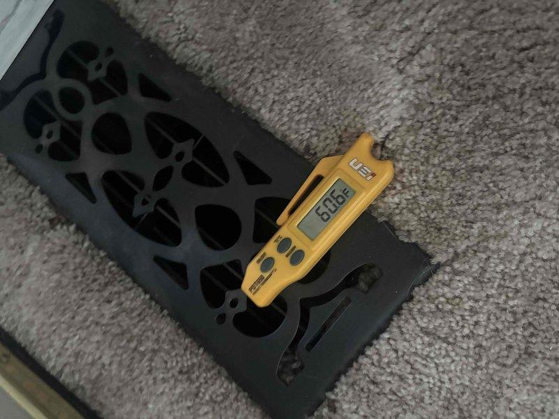 Responded to service call for thermostat concerns after reported tampering with unit settings. Performed diagnostic assessment of HVAC system operation and measured airflow output at floor register using digital testing equipment, recording temperature readings of 80.6°F to verify proper system performance and air distribution throughout the conditioned space.
