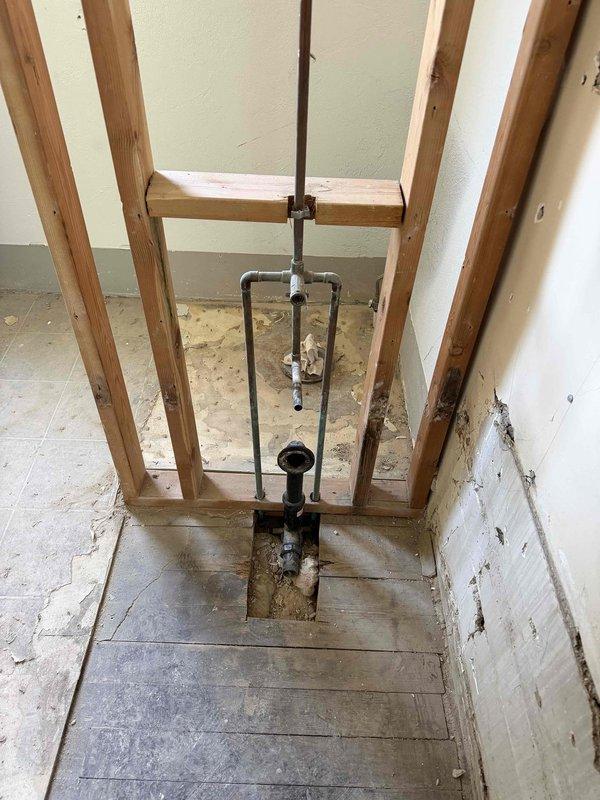 Responded to upstairs bathroom plumbing repair for shower system issues. Raised the copper shower head supply pipe to the proper height and repaired a malfunctioning four-way valve. Work required opening wall framing to access the vertical plumbing assembly and reconfiguring the pipe runs. Installed new valve components and secured all connections with proper fittings. Tested system for leaks and verified proper water flow and temperature control through all valve positions. All plumbing brought to code and left in full working order.