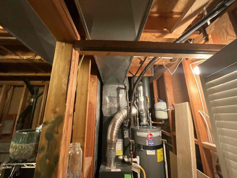 Responded to service call for 16-year-old residential cooling system experiencing insufficient cooling and reduced airflow, with thermostat set at 70°F but unable to achieve temperature below 75°F. Performed comprehensive diagnostic evaluation of single outdoor condensing unit and furnace system. Testing revealed condenser fan motor drawing excessive amperage beyond manufacturer specifications, indicating motor failure and potential compressor stress. Additional components found operating below specification parameters, compromising overall system efficiency and cooling capacity. Documented equipment condition through photographic evidence showing outdoor condensing unit installation and attic-mounted furnace configuration. Provided technical assessment and repair options for aging system requiring multiple component replacements to restore proper operation.