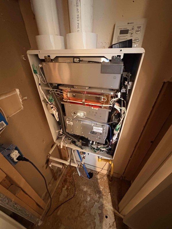 Responded to no hot water condition on 11-year-old tankless water heater displaying error code 90. Inspected unit with front panel removed, examined internal components including heat exchanger, gas valve, ignition system, and venting connections. Diagnosed combustion failure indicated by error code 90, which was not resolved by standard reset procedure. Evaluated system pressure, electrical connections, and gas supply to isolate failure point.
