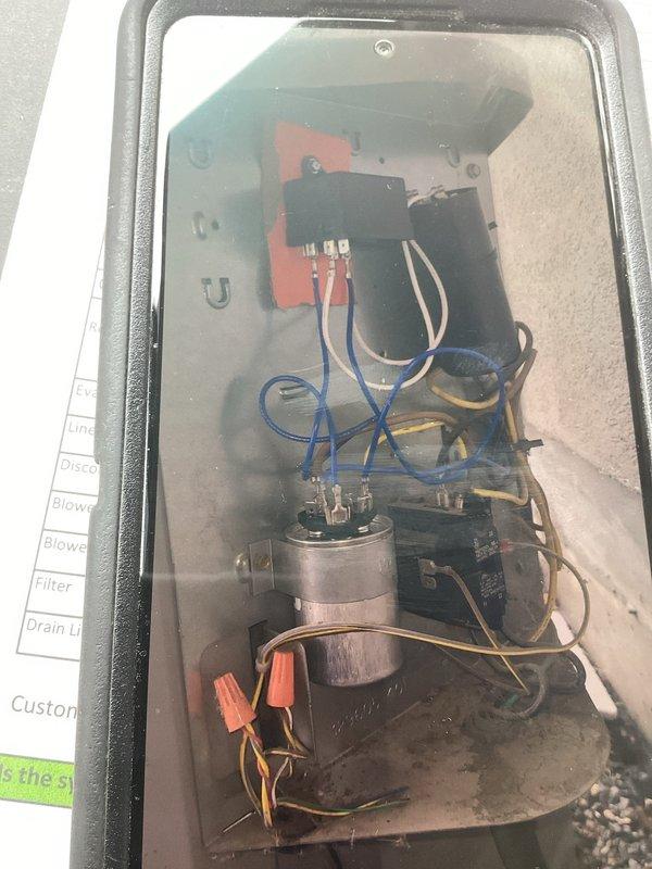 Responded to no-cooling complaint on 2019 residential central air conditioning system. Upon arrival, located outdoor condenser unit on gravel pad against building exterior. Performed diagnostic evaluation of system operation. Accessed electrical compartment and inspected internal components including capacitor, contactor relay, and associated wiring connections. Documented equipment condition with photographs of condenser unit exterior and electrical compartment showing capacitor, wire connections with wire nuts, and relay assembly. Unit found running but failing to provide adequate cooling to conditioned space.