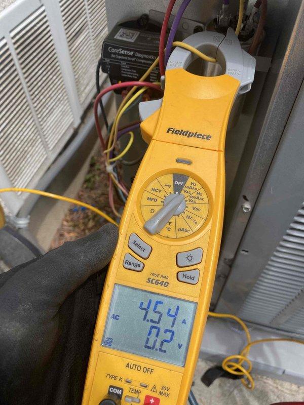 Completed preventive maintenance on 4-year-old ground-level cooling system as part of recurring membership service with no reported issues. Performed comprehensive system diagnostics using digital multimeter to verify electrical readings, including voltage measurements at 0.2V and capacitance testing at 454µF, along with amperage draw verification showing 64.1A. Inspected all electrical connections, control board wiring, and CoreSense diagnostic monitoring system to ensure proper operation and system efficiency.