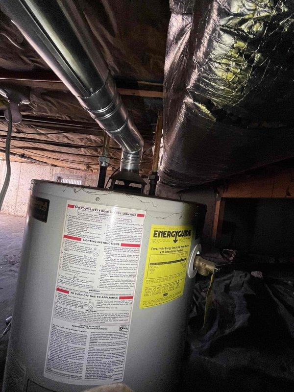Responded to no hot water complaint and inspected 20+ year old tank-style water heater located in crawl space. Assessed unit condition and confirmed age beyond expected service life, documented equipment with photos for replacement estimate. Provided customer with repair versus replacement options for aging water heater system.