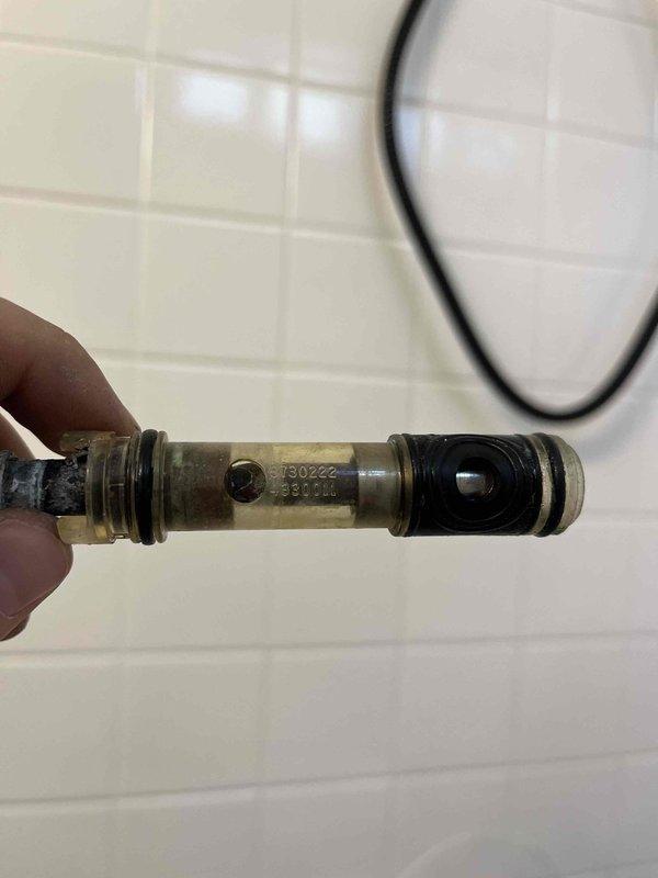 Responded to report of water leaking from beneath tub spout and around faucet handle in master bathroom shower/tub combination. Upon inspection, identified faulty shower diverter valve assembly causing water to bypass seals and leak at multiple points during operation. Removed existing worn diverter cartridge, which exhibited significant mineral buildup and deteriorated internal seals contributing to the leak. Installed replacement diverter assembly and tested operation to confirm proper water flow direction and complete elimination of leaks at both tub spout and handle locations.