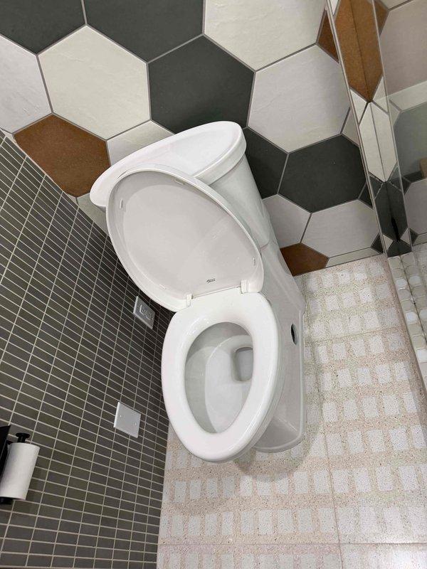 Responded to callback for toilet leak at base following bidet installation. Upon inspection, found deteriorated wax ring seal and compromised toilet flange connection causing water seepage onto tile floor. Removed toilet to access flange assembly, which showed signs of age and wear with visible discoloration and residue buildup around mounting area. Replaced wax ring seal with new unit and reinstalled toilet, ensuring proper alignment with closet bolts and secure mounting to floor flange. Verified all connections were watertight and tested flush operation multiple times to confirm leak was resolved. Toilet reinstalled successfully with no further water discharge at base.