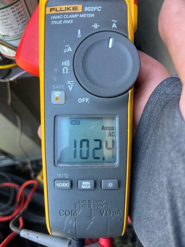 Responded to no cooling complaint on 17-year-old single-zone HVAC system. Upon arrival, confirmed outdoor condenser fan motor operating but unit not producing cold air with no visible frost or ice formation. Performed diagnostic evaluation and identified failed capacitor with visible oil leakage. Recorded equipment nameplate data including compressor specifications (20.7 RLA, 137 LRA) and fan motor ratings (1.2 FLA) for proper replacement sizing. Verified compressor operation and electrical connections. Installed turbo capacitor as replacement with five-year warranty coverage. Tested system operation using clamp meter, confirming proper amperage draw of 102.4 amps AC. System restored to full cooling operation and left running normally.