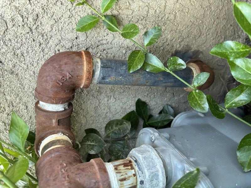 Responded to service call for slow water drip from tankless water heater that failed to restart. Upon inspection, diagnosed multiple critical failures on 8-9 year old unit including leak at heat exchanger with visible rust deterioration, failed water softener system, and malfunctioning pressure reducing valve. Determined unit had reached end of serviceable life due to age and extent of component failure. Presented comprehensive repair options including full system replacement of tankless water heater, water softener replacement, and pressure reducing valve replacement. Explained warranty requirements necessitate proper water softening and pressure regulation to protect new equipment. Discussed financing options and provided detailed breakdown of replacement scenarios with varying levels of component inclusion. Documented existing conditions showing significant corrosion on exterior plumbing components and current equipment storage configuration in basement area.