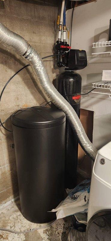 Installed a Navien 240A tankless water heater on a plywood backing board securely mounted to the basement wall. Removed and hauled away the old water heating equipment. Re-routed venting to the exterior with new termination plate installation. Secured and reworked the gas line, installing a new gas stop, sediment trap, isolation valves, ball valve, and expansion tank. Reconfigured water lines with proper connections to the new unit.

Installed a Sentry II 48k grain water softener system with new brine tank and loaded with five bags of salt. Completed all necessary plumbing connections between the softener and water heater systems. Installed a new Watts 3/4" AUB pressure reducing valve and adjusted system pressure to proper specifications.

Conducted comprehensive system testing, verified all connections for leaks, and confirmed proper operation of both the tankless water heater and water softener system.