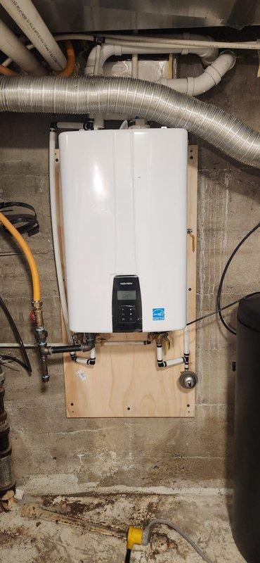 Installed a Navien 240A tankless water heater on a plywood backing board securely mounted to the basement wall. Removed and hauled away the old water heating equipment. Re-routed venting to the exterior with new termination plate installation. Secured and reworked the gas line, installing a new gas stop, sediment trap, isolation valves, ball valve, and expansion tank. Reconfigured water lines with proper connections to the new unit.

Installed a Sentry II 48k grain water softener system with new brine tank and loaded with five bags of salt. Completed all necessary plumbing connections between the softener and water heater systems. Installed a new Watts 3/4" AUB pressure reducing valve and adjusted system pressure to proper specifications.

Conducted comprehensive system testing, verified all connections for leaks, and confirmed proper operation of both the tankless water heater and water softener system.