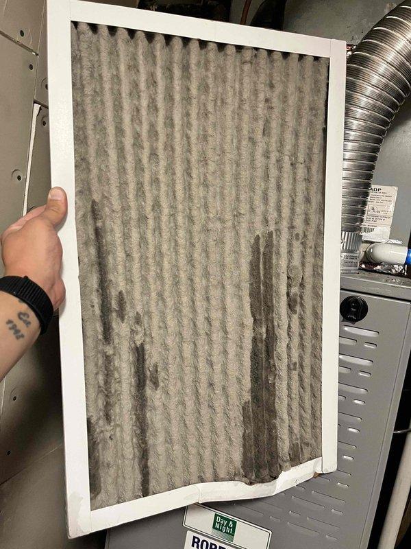 Responded to no-cooling call on residential split system with 20+ year-old equipment. Performed comprehensive Cool 10+ preventive maintenance inspection on outdoor condenser unit and indoor air handler located in basement. Outdoor unit showed significant weathering and surface wear consistent with age; inspected electrical connections, refrigerant lines, and condenser coil condition. Indoor inspection revealed heavily soiled air filter with substantial dust and particulate accumulation restricting airflow. Replaced dirty air filter with new unit to restore proper system airflow and efficiency. Verified system operation and cooling performance upon completion of maintenance service.