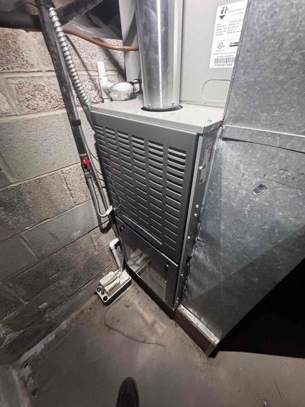Responded to service call for air conditioning unit making abnormal noise for approximately one week, suspected to be fan-related. Accessed furnace system located in bedroom crawl space via ladder and inspected air handler unit with ventilated front panel and refrigerant lines. Performed diagnostic evaluation of AC unit located on east side of property through gate access. Conducted visual inspection of mechanical components including heat exchanger, blower assembly, and associated ductwork connections. Documented equipment condition through photographic records showing furnace installation, copper refrigerant lines with insulation sleeves, and system components. Coordinated arrival within requested afternoon timeframe to accommodate property access requirements.