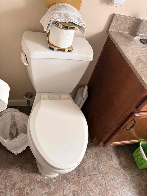Responded to reported leak from main level bathroom toilet causing water intrusion into basement ceiling. Inspected toilet fixture and surrounding area to identify source of leak penetrating through floor assembly. Documented conditions and leak location for repair assessment.