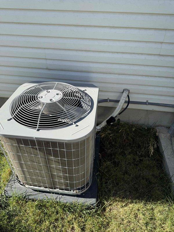 Responded to a no cooling complaint on a single-zone residential HVAC system approximately 7 years old. Inspected outdoor condensing unit located on north side of property and indoor air handling equipment situated in laundry area. Documented system conditions through photographs showing exterior condenser unit on concrete pad with refrigerant lines and basement/crawl space installation with ductwork and insulation. Provided technical assessment and estimate for necessary repairs to restore cooling operation.